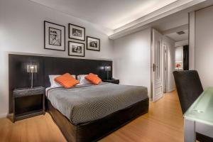 um quarto com uma cama com duas almofadas cor-de-laranja em Broadway Hotel & Suites em Buenos Aires