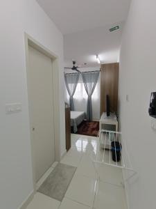 a white room with a door and a bedroom at Qilayna guest room in Sepang