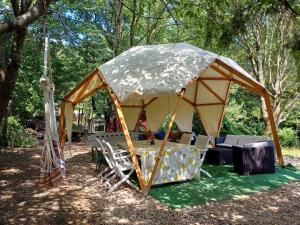 uma tenda com cadeiras e uma mesa numa floresta em Jurta az erdő mellett dézsával-KERESZ-TANYA em Pilisszentkereszt