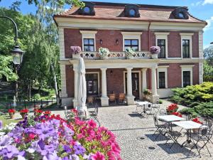 uma casa com um ramo de flores à frente dela em Hotel Charlotta em Jedlina-Zdrój