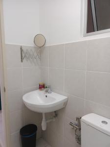 a bathroom with a sink and a toilet at Qilayna guest room in Sepang