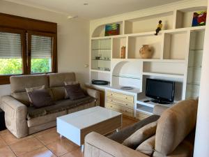 sala de estar con sofá y TV en Agrelo Playa, en Bueu