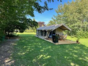 a yurt with a table and chairs in a field at Langø Feriecenter - Outdoor Lodge in Nakskov