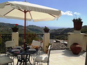 a patio with an umbrella and a table and chairs at Palazzo Lupis B & B Grotteria Calabria Italia in Grotteria +12 photos