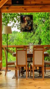 une salle à manger avec une table, des chaises et un tableau dans l'établissement Pensjonat Uroczysko Zaborek, à Janów Podlaski