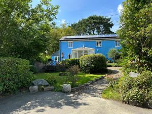 a blue house with a garden in front of it at Bay View Cottage in St Austell