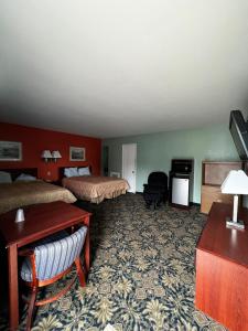 a hotel room with two beds and a desk at Town & Country Motel in Sioux City