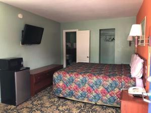 een hotelkamer met een bed en een flatscreen-tv bij Town & Country Motel in Sioux City