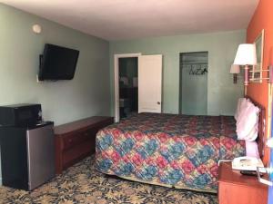 a hotel room with a bed and a flat screen tv at Town & Country Motel in Sioux City
