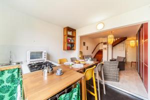 eine Küche und ein Wohnzimmer mit einem Tisch und einem Herd in der Unterkunft Le Fare de Lilizoe in Le Bois de Nèfles