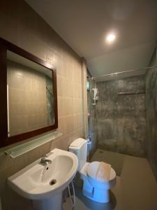 W łazience znajduje się umywalka, toaleta i lustro. w obiekcie Kiriraya Resort w Aonang Beach