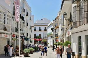 a group of people walking down a street with buildings at Fancy apartment in a Historic house, Chiclana City Center by C. Dreams in Chiclana de la Frontera