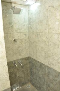 a bathroom with a shower with a stone wall at Sagar homestay in Thanjāvūr