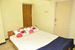 um quarto com uma cama com duas almofadas em Sagar homestay em Thanjāvūr