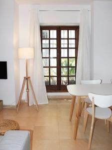 a living room with a table and chairs and a window at Fancy apartment in a Historic house, Chiclana City Center by C. Dreams in Chiclana de la Frontera