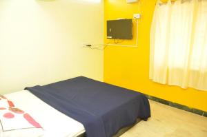ein Krankenhauszimmer mit einem Bett und einem TV in der Unterkunft Sagar homestay in Thanjavur