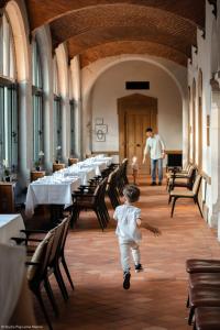 a young boy running through a room with tables at Fourvière Hôtel in Lyon