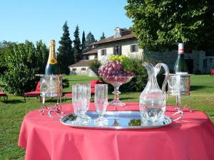 una mesa con copas de vino y un tazón de uvas en Agriturismo Beria de Carvalho de Puppi en San Giovanni al Natisone