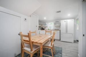 eine Küche mit einem Holztisch und Stühlen sowie einem Kühlschrank in der Unterkunft Downtown Houston Oasis - Walk to TSU or UH in Houston