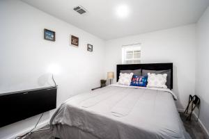 ein Schlafzimmer mit einem großen Bett mit weißen Wänden in der Unterkunft Downtown Houston Oasis - Walk to TSU or UH in Houston