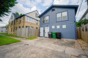 ein blaues Haus mit zwei Mülltonnen in einer Einfahrt in der Unterkunft Downtown Houston Oasis - Walk to TSU or UH in Houston