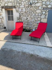 twee rode stoelen voor een gebouw bij Clos PIMI in Monbazillac