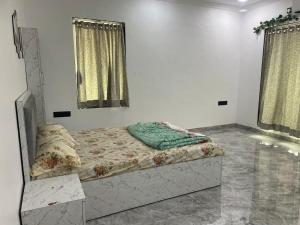 uma cama num quarto branco com duas janelas em Classic Villa em Pālghar