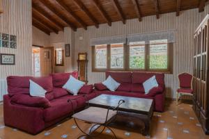 a living room with a red couch and a table at Zafiro lagunazo Riopar 5 Dormitorios 3 Baños Parque Natural del Rio Mundo in Riópar