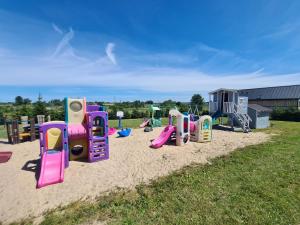 a playground with a bunch of play equipment in the sand at Domki Róża Bobolin in Bobolin