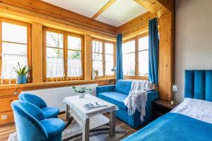 1 dormitorio con sillas azules, 1 cama y 1 mesa en Willa Jasinek, en Zakopane