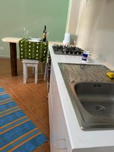 a kitchen with a stainless steel sink and a table at B&B Mi Ma Bo, Sal Rei, Boa Vista, Cape Verde, FREE WI-FI in Sal Rei