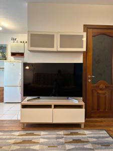 TV de pantalla plana grande en la sala de estar. en Biliūno g. 5 apartamentas 1-am aukšte su didele terasa, en Palanga