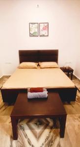 a bed in a room with a table with a bedspread at Zoeys Homestay - 1BHK with Free Breakfast in Jammu