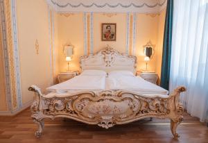 1 cama ornamentada en un dormitorio con 2 lámparas en Pension Bellevue, en Múnich