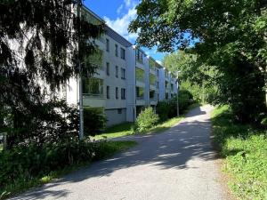 an empty road in front of a white building at 2 br apartment w/ balcony, wifi, parking in Espoo