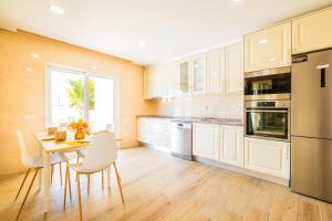a kitchen with white cabinets and a table and chairs at Villa Impasse - Albufeira in Albufeira