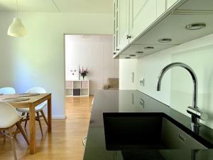 a kitchen with a sink and a table and a dining room at 2 br apartment w/ balcony, wifi, parking in Espoo