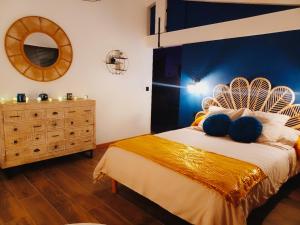 a bedroom with a large bed and a dresser at Le Moulin de l'Asse Chambre d'Hôtes in Bras-dʼAsse