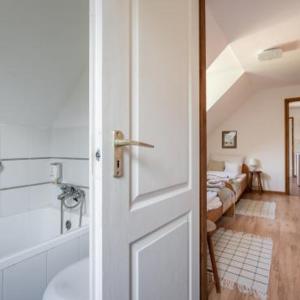 a door to a bathroom with a tub and a bedroom at Brancs Rancs in Dunabogdány +36 photos