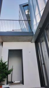 a house with a glass door and a balcony at CASA dos MIÑOS in Cangas de Morrazo