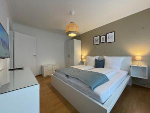 a bedroom with a large white bed and a television at Cityapartment SB Am Homburg in Saarbrücken