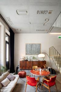 uma sala de estar com uma mesa e um sofá em Hotel Tipografia do Conto by Casa do Conto no Porto