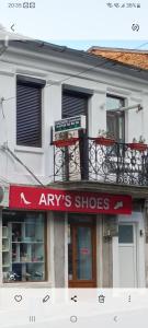 a shop with a red sign on the side of a building at CAZARE Centrum in Curtea de Argeş