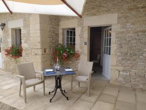 einen Tisch und Stühle auf einer Terrasse in der Unterkunft Chambres Résidentielles avec cuisine au Manoir de Mathan à Crépon 5 mn D'Arromanches et 10 mn de Bayeux in Crépon
