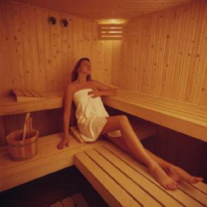 Eine Frau sitzt in einer Sauna in der Unterkunft IQBAL-Hütte FeWo Appartement - Ankerplatz in Beverstedt