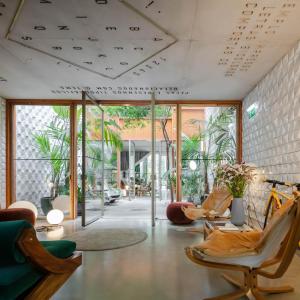 un salon avec des chaises, des tables et des fenêtres dans l'établissement Hotel Tipografia do Conto by Casa do Conto, à Porto