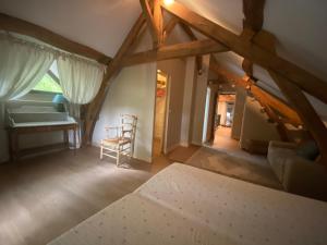 Zimmer im Dachgeschoss mit einem Tisch und einem Stuhl in der Unterkunft Pavillon d’entrée du château de Bouesse in Bouesse