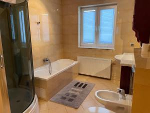 a bathroom with two sinks and a tub and a toilet at Villa Upwind in Osłonino