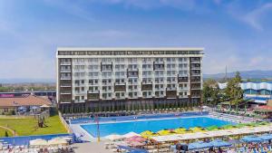 a hotel with a large swimming pool in front of a building at Bella Vista in Jagodina