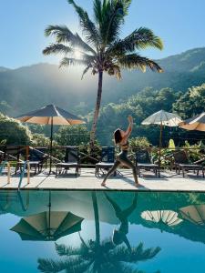 a woman is walking by a swimming pool at Casa Grande Mountain Retreat - Adults Only in Utuado